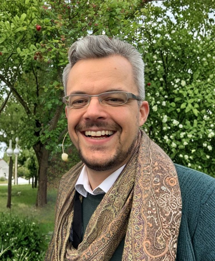 Tobias Danzer lachend mit Schal im Park